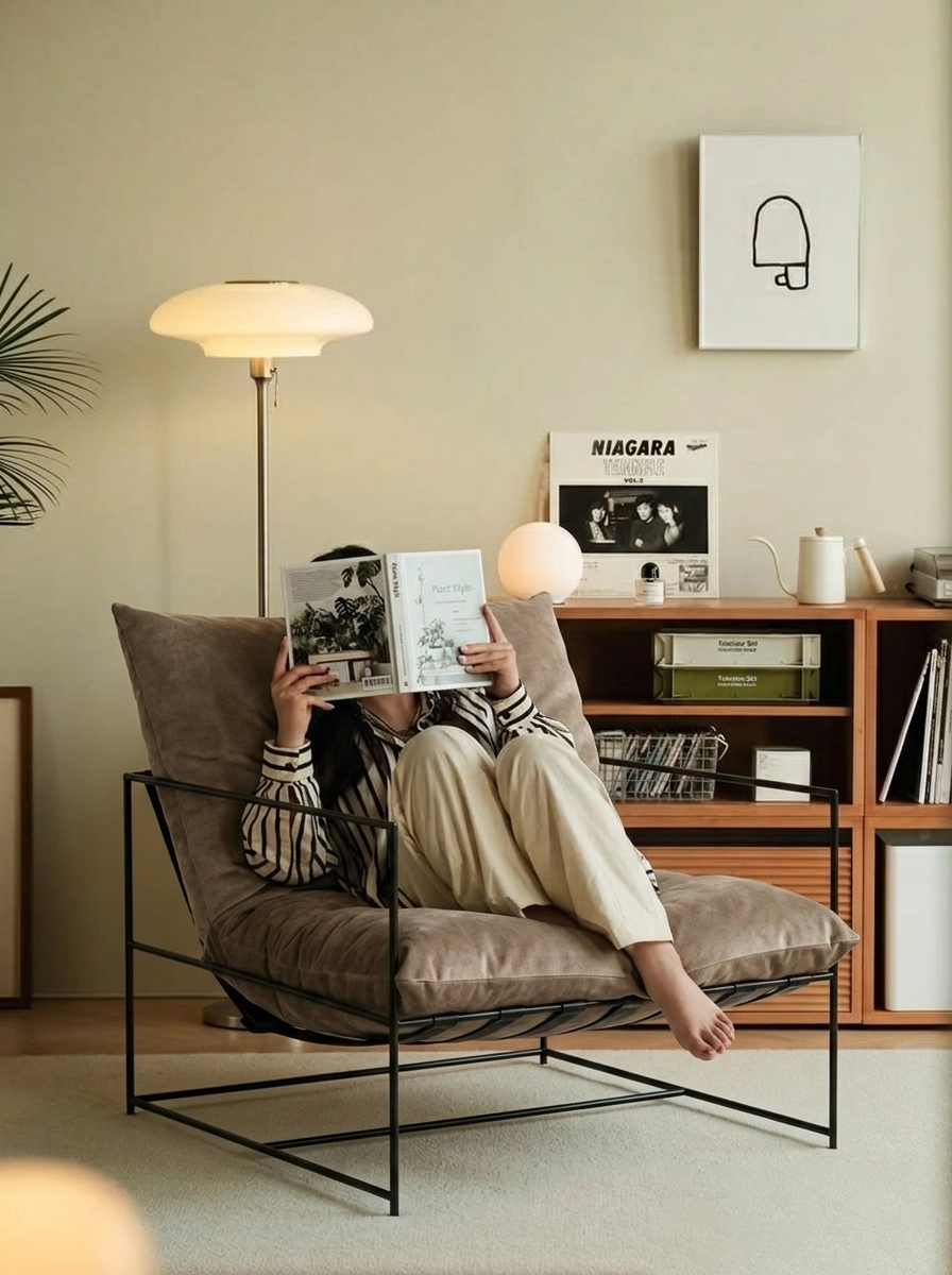 Someone curled up reading in The Drift in Latte, under warm lamplight